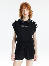 A lady wears a knitted top and shorts.